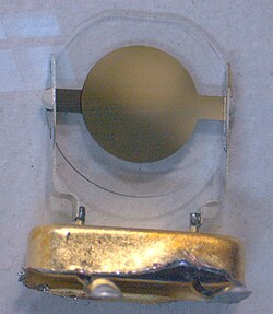 Capacitor-like metalisation forming the connection on a disc of clear crystal material