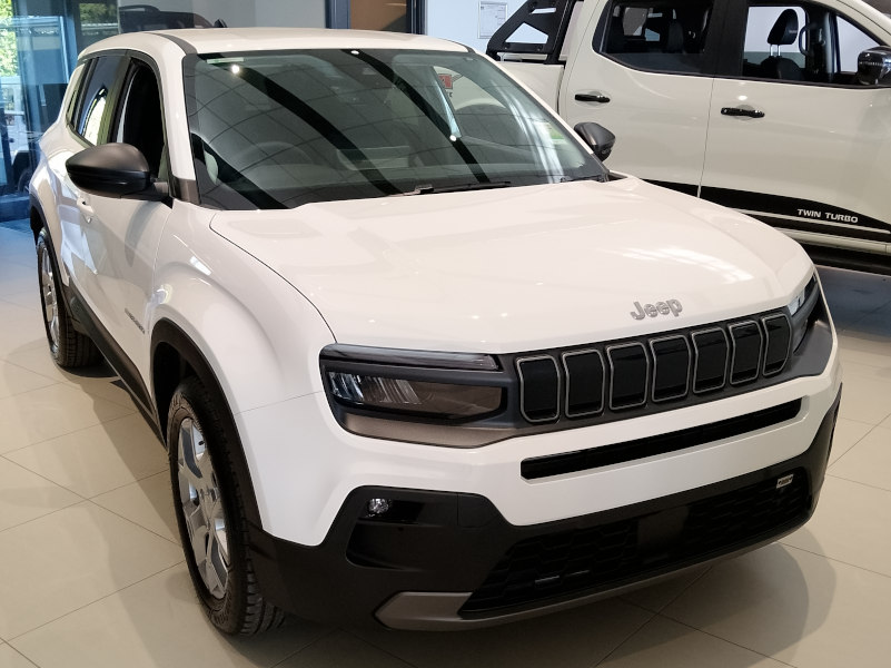 Jeep in white inside a showroom, front view with the right side shown.